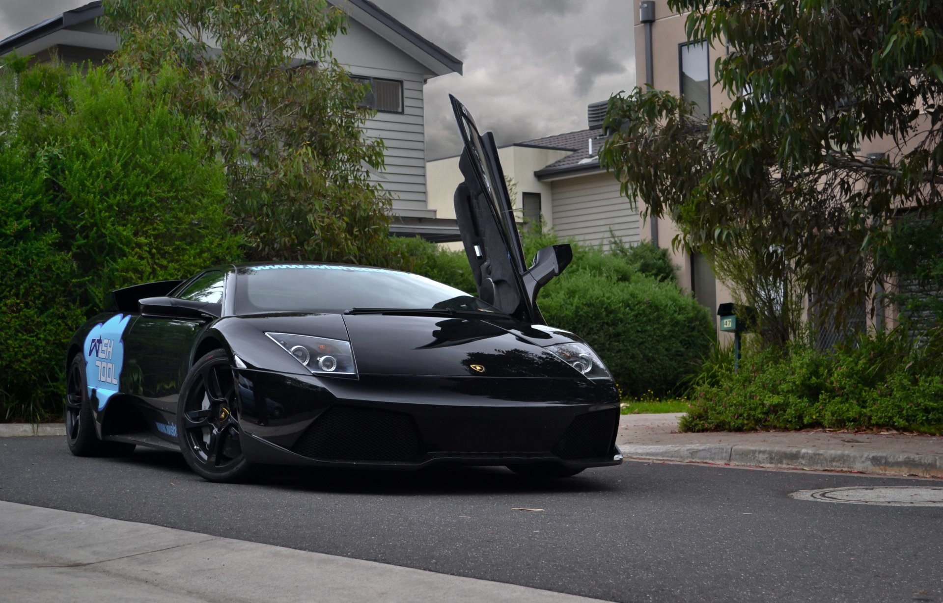 lamborghini murcielago lp560 czarny lamborghini murcielago widok z przodu drzewa budynki