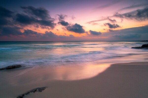 Różowe niebo odbija się w wodach spokojnego morza